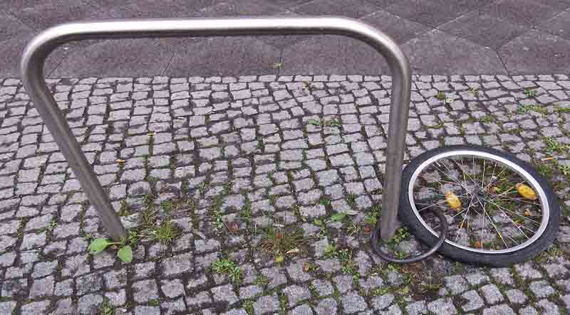 Ein Reifen eines Fahrrades angekettet an einer Stange.
(c) Pixabay.com