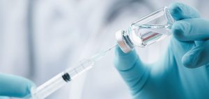 Corona-Impfung – wer noch keine hat, sollte das rasch nachholen Die Hände eines Arztes, der einen Impfstoff aus einer Ampulle mit einer Spritze aufsaugt. (c) AdobeStock