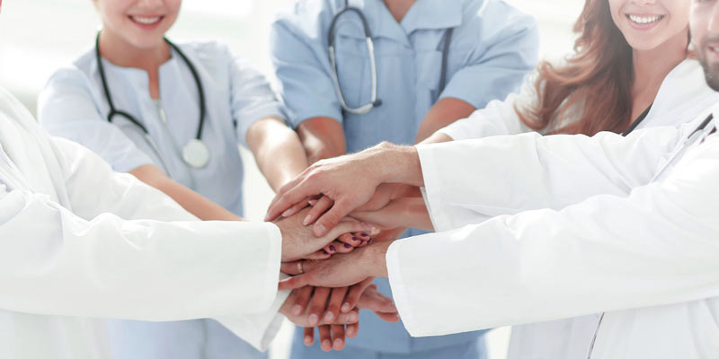"Because there is more to do" – für Patient•innen & die Gesellschaft 2 Medizinisches Personal, das die Hände zusammen gibt, Stichwort Teamwork.
(c) AdobeStock