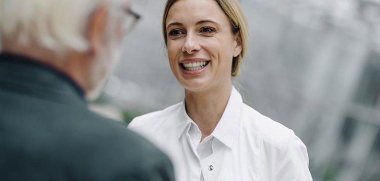 Das lachende Gesicht einer Frau, die mit einem Mann redet. (c) Bristol Myers Squibb