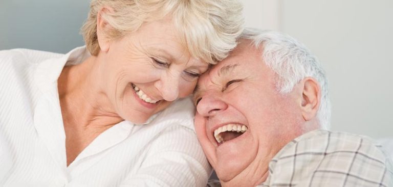 Die Köpfe eines älteren Paares, das gemeinsam lacht. (c) AdobeStock