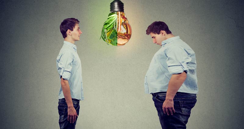 Ein dünner und ein übergewichtiger Mann, die sich gegenüber stehen. Von oben hängt eine Glühbirne herab, die auf der Seite des dünnen Mannes Gemüse beinhaltet, auf der des übergewichtigen Junk Food.
(c) AdobeStock