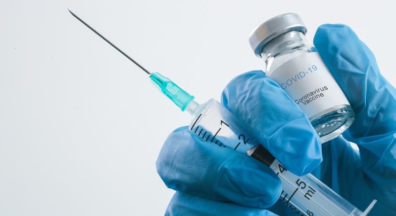 "Wir brauchen einen nationalen Schulterschluss" – #ImpfenSchützt 2 Eine Hand mit Schutzhandschuh hält eine Ampulle Corona-Vaccine und eine Spritze.
(c) AdobeStock