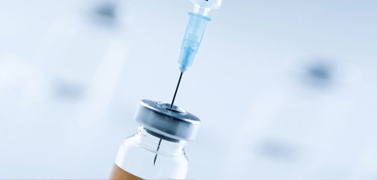 Eine Nadel einer Spritze in einer Ampulle mit einem Impfserum. (c) AdobeStock