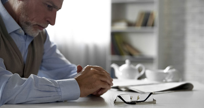 Alterseinsamkeit zu Weihnachten: spezielle Angebote unterstützen 1 Ein älterer Mann sitzt betrübt und einsam alleine an einem Tisch, Stichwort Alterseinsamkeit.
(c) AdobeStock