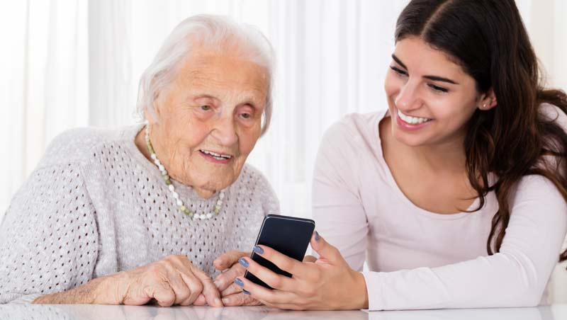 Eine alte Frau, die sich von einer jungen auf dem Smartphone etwas zeigen lässt, Stichwort Handyumzug.
(c) AdobeStock
