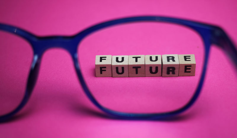 Das Wort Zukunft mit Scrabble-Steinen durch ein Brillenglas.
(c) AdobeStock