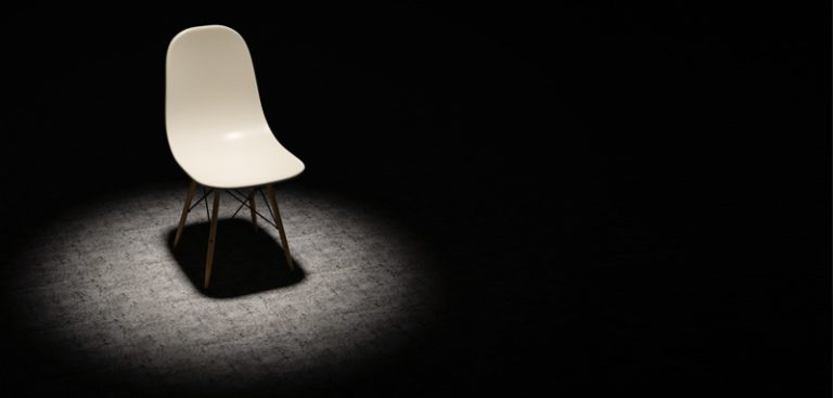 Ein leerer weißer Stuhl im Spotlight. (c) AdobeStock