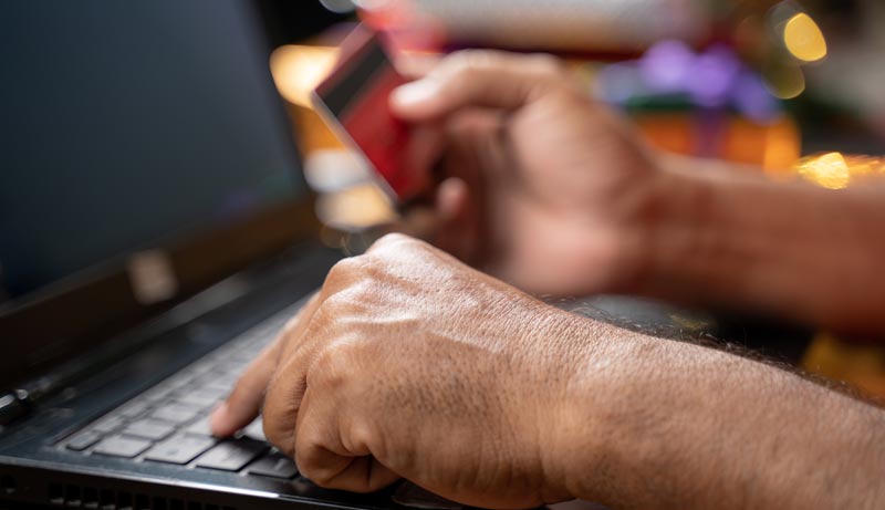 Die Hände eines Mannes, der auf einem Laptop seine Kreditkarteninfos eingibt, Stichwort Online-Shop.
(c) AdobeStock
