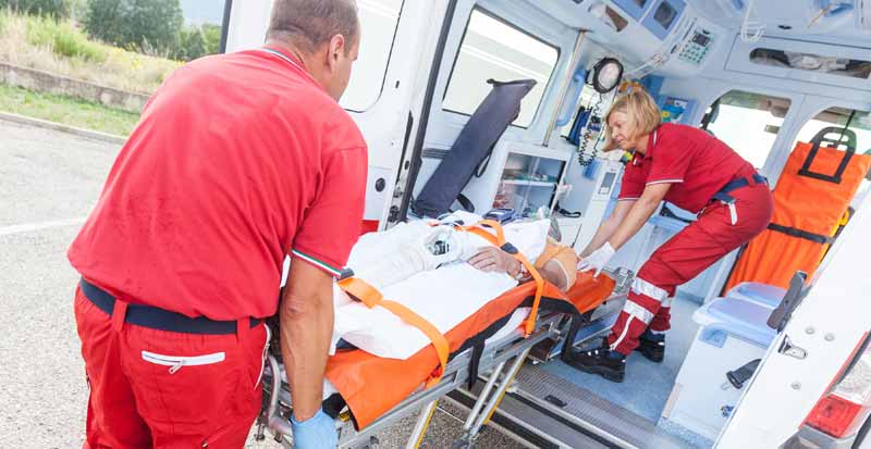 Rettungssanitäter, die einen Patienten in den Krankenwaagen schieben, Stichwort Schlaganfallrisiko.
(c) AdobeStock