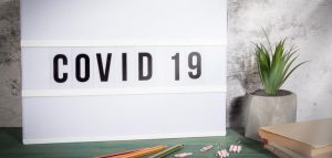 Long Covid: neue Studienlage zur Wirkung der Corona-Impfung Eine Tafel auf einem Tisch, auf der Covid 19 steht. (c) AdobeStock