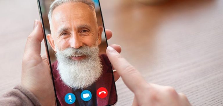 Das Gesicht eines alten Mannes auf einem Smartphone während eines Videocalls. (c) AdobeStock