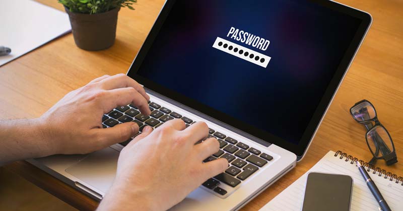 Die Hände eines Mannes auf einer Laptoptastatur beim Eingeben eines Passwortes.
(c) AdobeStock