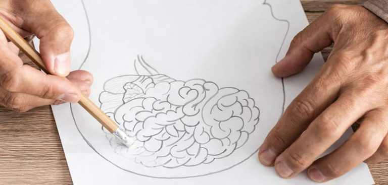 Die Hände eines Mannes, der bei einem gezeichneten Kopf mit Gehirn selbiges beginnt auszuradieren. (c) AdobeStock