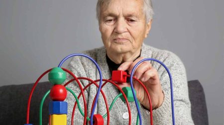 Ein alter Mann beim Spielen mit einem Geschicklichkeitsspiel für Kinder. (c) AdobeStock