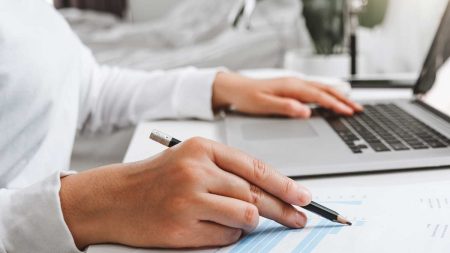 Die Hände einer Frau beim Arbeiten an einem Laptop. (c) AdobeStock