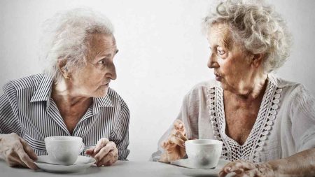 Zwei alte Frauen, die sich bei einer Tasse Kaffee miteinander unterhalten. (c) AdobeStock