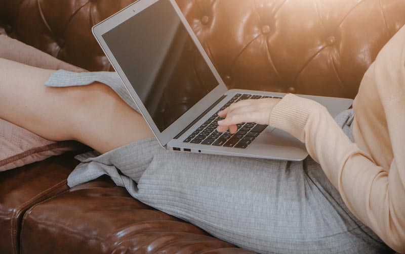 Eine Frau mit einem Laptop auf einer Couch.
(c) AdobeStock