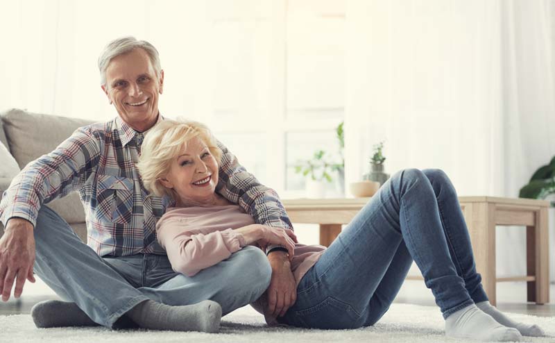 Ein älteres Paar gemütlich auf dem Teppich in ihrer Wohnung.
(c) AdobeStock