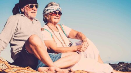 Ein älteres Hippie-Paar sitzt in der Sonne. (c) AdobeStock
