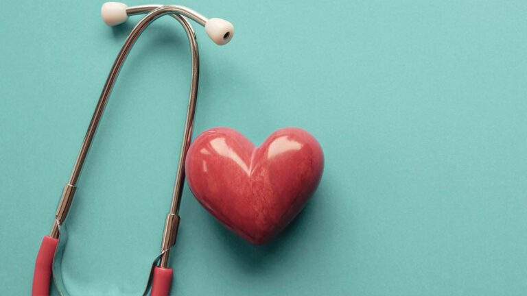 Ein Stethoskop neben einem rotem Herzen. (c) AdobeStock