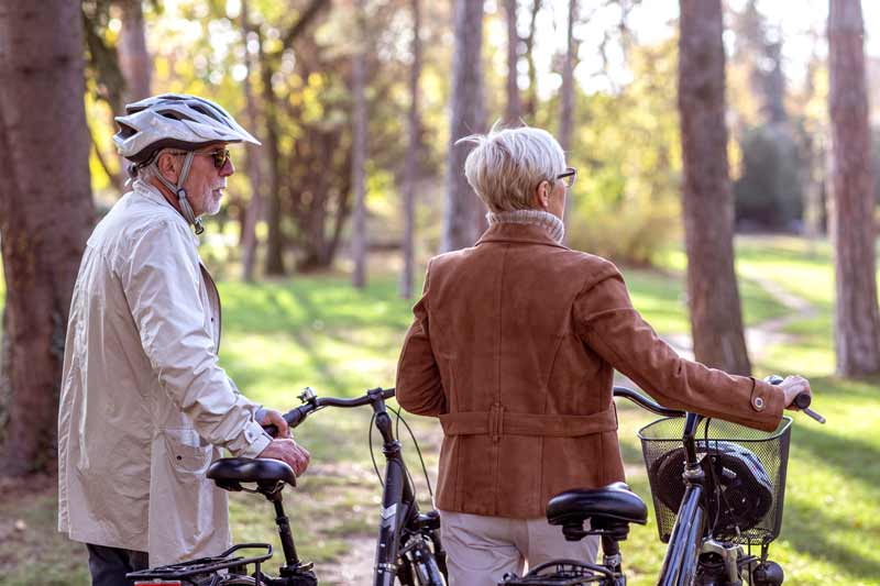 Ein älteres Paar mit ihren Fahrrädern in einem Park.
(c) AdobeStock
