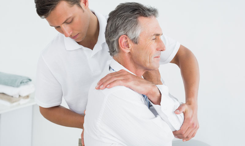 Ein Therapeut, der bei einem Patienten den Rücken behandelt.
(c) AdobeStock