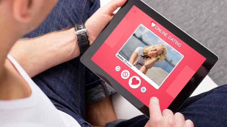 Die Hände eines Mannes, der ein Tablet hält, auf dem er eine Online-Dating Seite offen hat. (c) AdobeStock