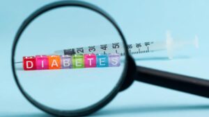 Eisberg voraus! Weiterhin schlechte Diabetes mellitus Typ 2-Datenlage Blick durch eine Lupe auf das Wort Diabetes, das mit Scrabblesteinen gelegt wurde, dahinter eine Spritze. (c) AdobeStock