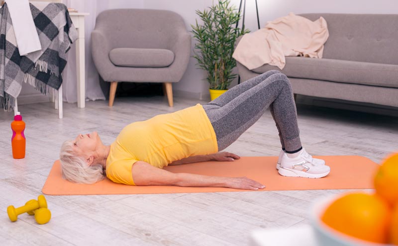 Ein Frau auf einer Yogamatte macht eine Übung, Stichwort Muskeltraining.
(c) AdobeStock