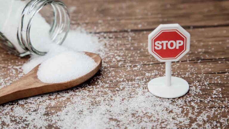 Weißer Zucker, daneben ein Stop-Schild. (c) AdobeStock