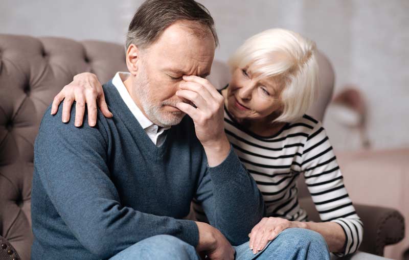 Eine ältere Frau, die einen Mann tröstet, Stichwort Depressionen.
(c) AdobeStock