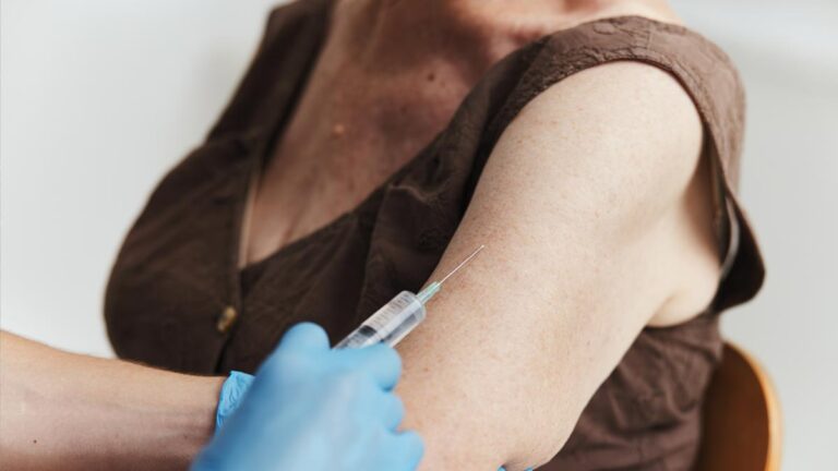 Der Oberarm einer älteren Frau, die eine Impfung bekommt. (c) AdobeStock