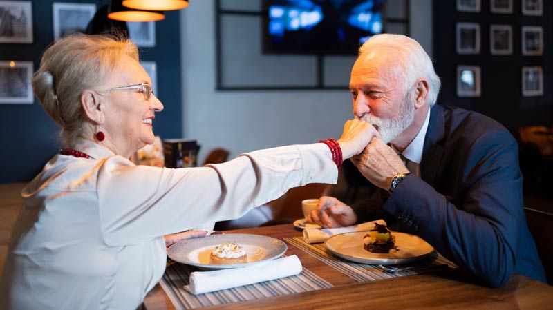 Ein älteres Paar beim Dinner; der Mann gibt der Frau einen Handkuss, Stichwort Liebe.
(c) AdobeStock