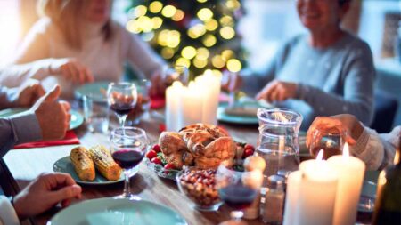 Ein festlich gedeckter Tisch einer Familie beim weihnachtlichen Festessen. (c) AdobeStock