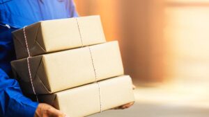 Probleme bei Paketzustellungen – Tipps für Konsumentinnen und Konsumenten Ein Paketzusteller mit drei Paketen. (c) AdobeStock