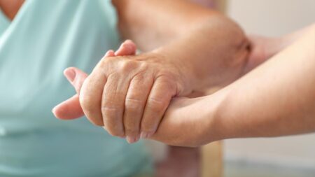 Die Hand einer jungen Frau, die die Hand einer alten hält bzw. ihr beim Aufstehen hilft. (c) AdobeStock