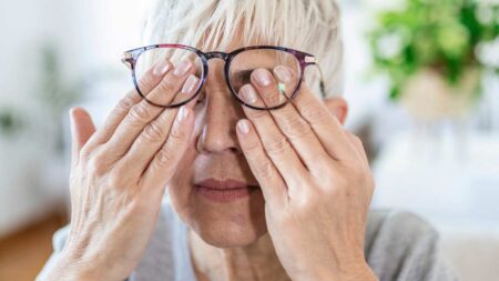 Eine ältere Frau, die sich die Augen reibt. (c) AdobeStock