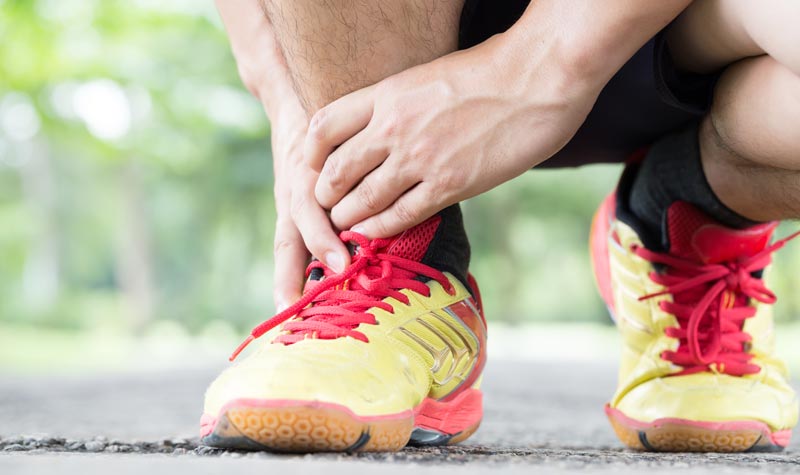 Fußverletzungen beim Sport und im Alltag: Umknicken und Sprunggelenksverletzung vorbeugen und richtig behandeln 2 Ein Mann greift sich mit beiden Händen an sein Fußgelenk.
(c) AdobeStock