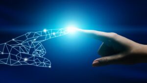 Die Zeigefinger einer weiblichen Hand und einer Roboterhand berührern sich. (c) AdobeStock