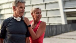 Ein älteres Paar im Trainingsoutfit vor dem Workout im Freien. (c) AdobeStock