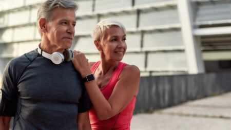 Ein älteres Paar im Trainingsoutfit vor dem Workout im Freien. (c) AdobeStock