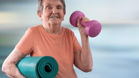 Eine alte Frau mit einer Hantel und einer Trainingsmatte. (c) AdobeStock