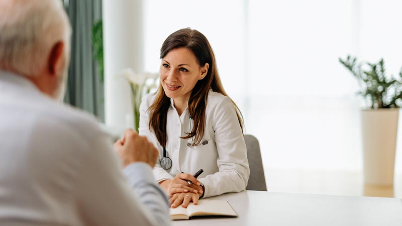Vor der Reise ist nach dem Impfpasscheck – selbst in Europa sollten die Standardimpfungen immer aktuell sein 1 Eine Ärztin im Gespräch mit einem älteren Patienten, Stichwort Impfpasscheck.
(c) AdobeStock