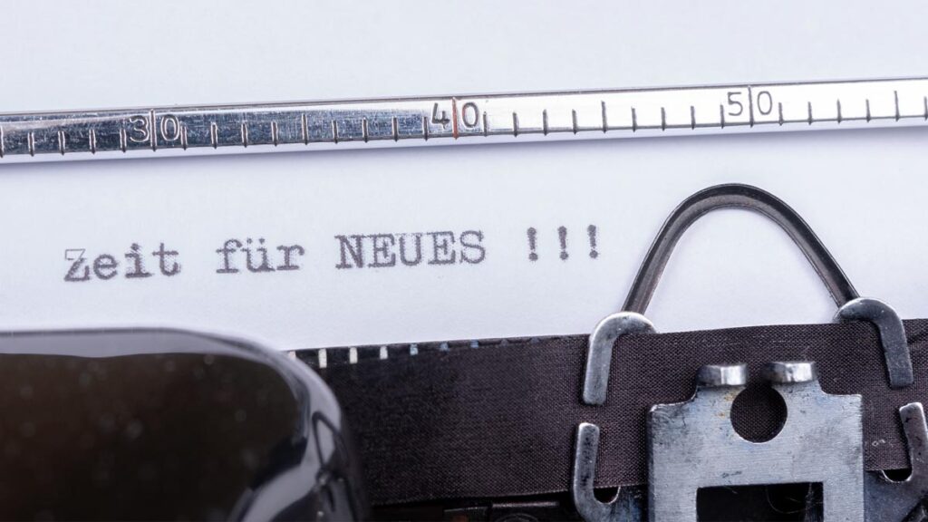 Ein Blatt in einer alten Schreibmaschine, auf dem "Zeit für Neues" steht. (c) AdobeStock