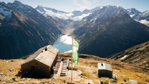 Reservierung nicht vergessen – Tipps für den nächsten Hüttenbesuch Eine Hütte in den Zillertaler Alpen mit darunter liegendem Stausee. (c) AdobeStock
