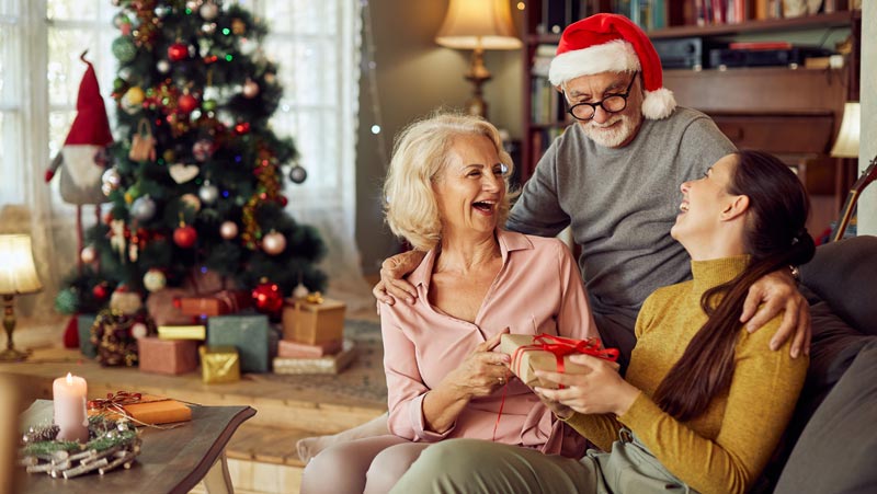 Damit sie nicht auf Weihnachtsgeschenken, Gutscheinen & Co. sitzenbleiben 2 Ein älteres Paar mit einer jüngeren Frau beim Austauschen von Weihnachtsgeschenken.
(c) AdobeStock