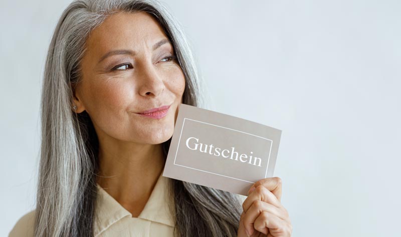 Damit sie nicht auf Weihnachtsgeschenken, Gutscheinen & Co. sitzenbleiben 1 Eine Frau mit einem Gutschein in der Hand.
(c) AdobeStock