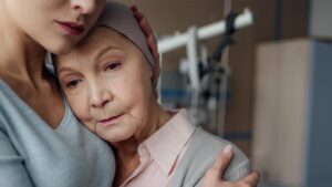 Eine ältere Frau, Krebspatientin, wird von eine jungen getröstet. (c) AdobeStock