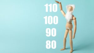 Holz-Gliederpuppe mit weißem Bart vor hellblauem Hintergrund, daneben stehen die Zahlen 110, 100, 90 und 80 als Symbole für hohe Lebenserwartung und Langlebigkeit. (c) AdobeStock